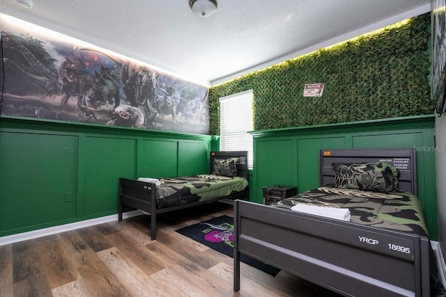 bedroom featuring hardwood / wood-style flooring and a textured ceiling