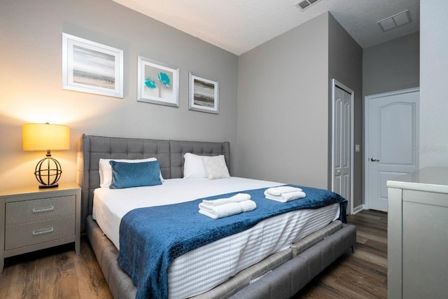 bedroom featuring dark wood-type flooring and a closet