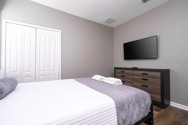 bedroom with a textured ceiling, a closet, and wood-type flooring