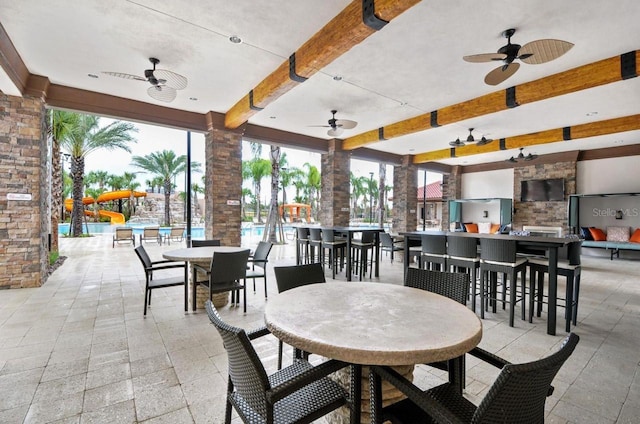 dining room with beam ceiling, ceiling fan, and light tile floors