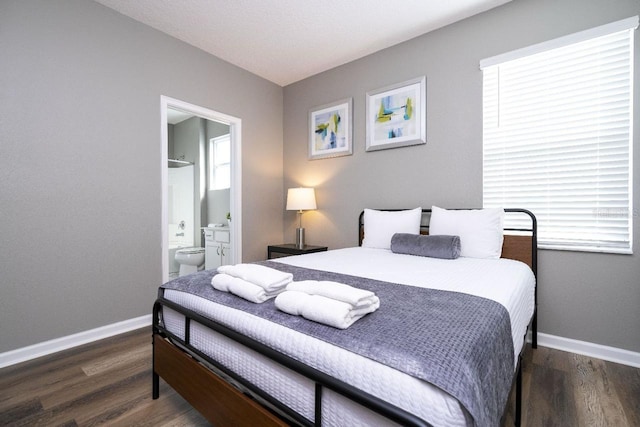 bedroom with ensuite bathroom and dark wood-type flooring