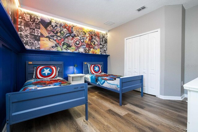 bedroom featuring hardwood / wood-style flooring, a closet, and a textured ceiling