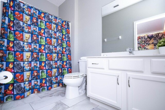 bathroom featuring vanity, toilet, and tile floors