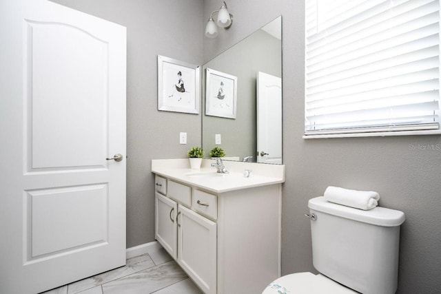 bathroom with tile flooring, oversized vanity, and toilet