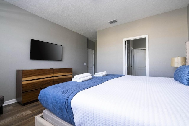 bedroom featuring a textured ceiling and dark wood-type flooring