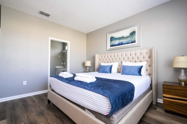 bedroom featuring dark hardwood / wood-style floors and a textured ceiling