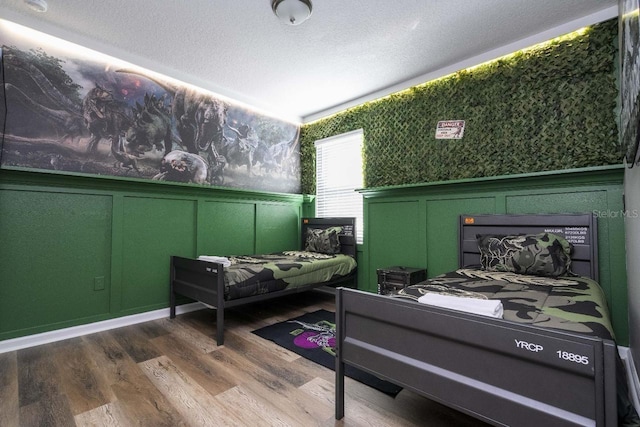 bedroom with a textured ceiling and hardwood / wood-style floors