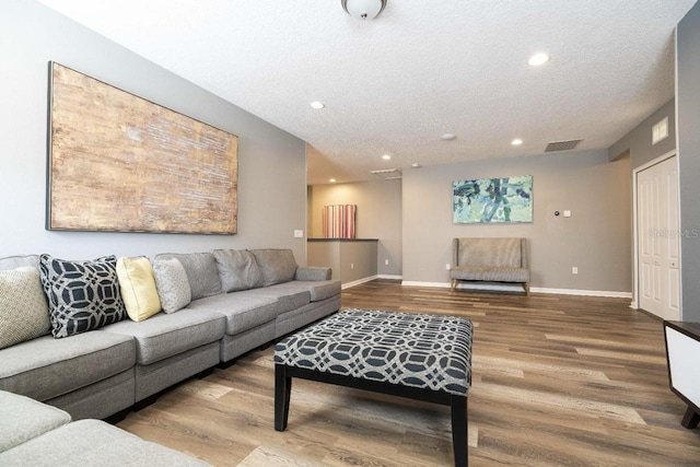 living room featuring wood-type flooring and a textured ceiling