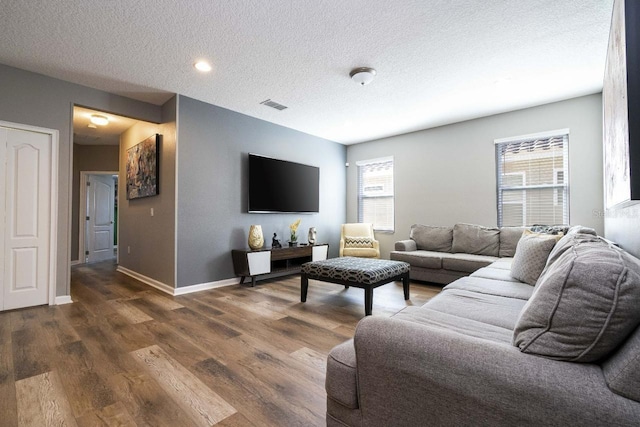 living room with dark wood-type flooring and a textured ceiling