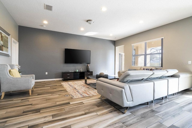 living room with hardwood / wood-style floors and a textured ceiling