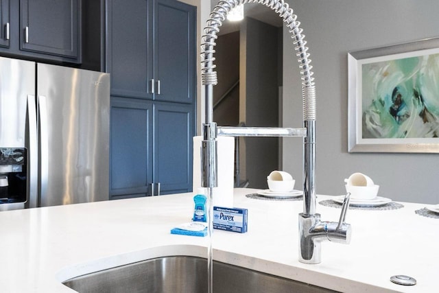 room details featuring stainless steel fridge and blue cabinets