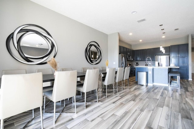 unfurnished dining area featuring sink and light hardwood / wood-style flooring