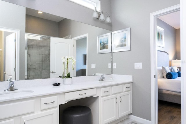 bathroom featuring wood-type flooring, large vanity, and dual sinks