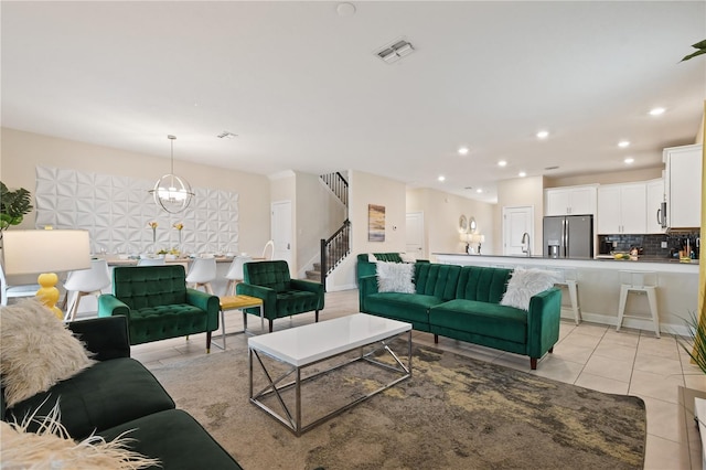 living room with sink, light tile patterned floors, and a chandelier