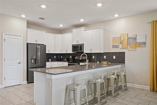 8834 Cabot Cliffs Dr, Davenport, FL 33896 - kitchen featuring stainless steel appliances, a peninsula, white cabinets, decorative backsplash, and recessed lighting