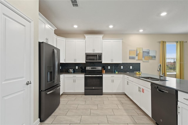 kitchen featuring backsplash, white cabinets, sink, light tile patterned flooring, and stainless steel appliances