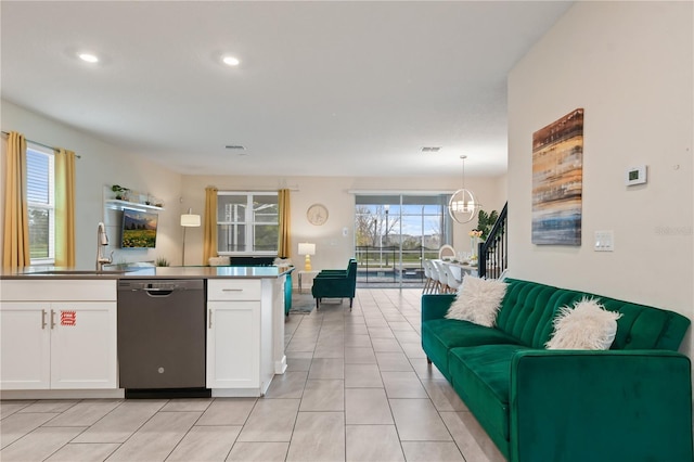 8834 Cabot Cliffs Dr, Davenport, FL 33896 - kitchen with stainless steel dishwasher, open floor plan, white cabinetry, recessed lighting, and light tile patterned flooring