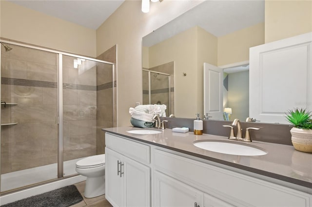 bathroom with tile patterned flooring, vanity, toilet, and walk in shower