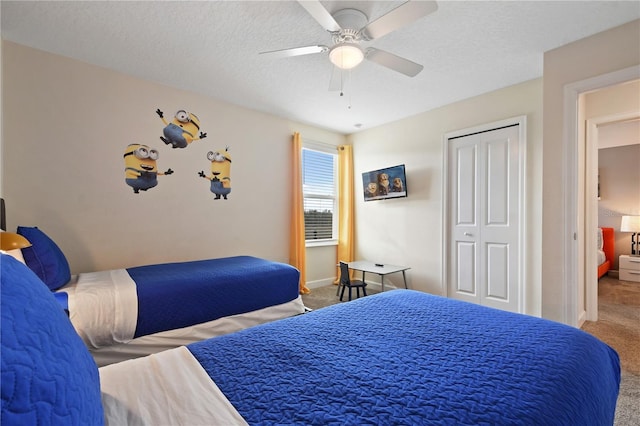 carpeted bedroom featuring ceiling fan, a closet, and a textured ceiling