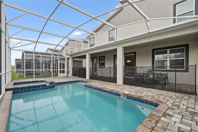 view of swimming pool with an in ground hot tub, a patio, and glass enclosure