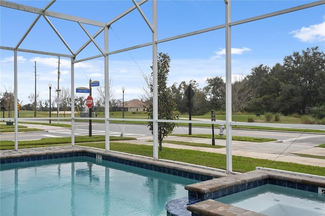 view of pool with a lawn and glass enclosure