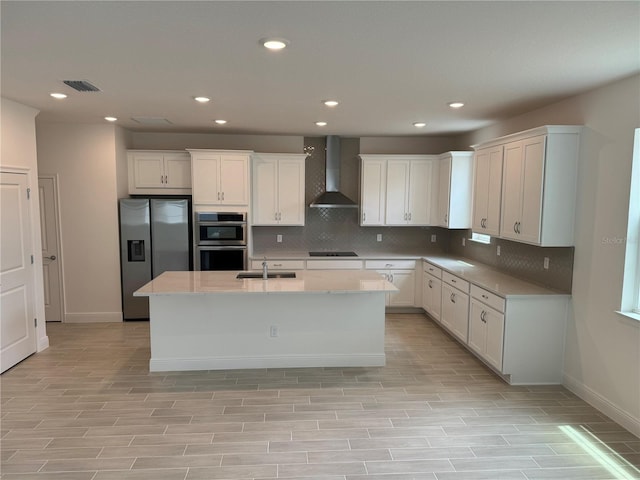 kitchen featuring white cabinetry, a kitchen island, appliances with stainless steel finishes, wall chimney exhaust hood, and backsplash