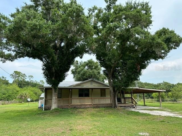 view of front of house featuring a front lawn, a carport, and a porch