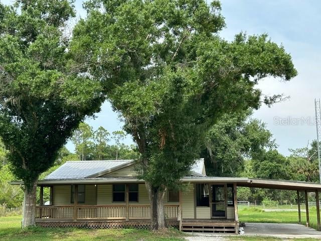 country-style home featuring covered porch and a carport