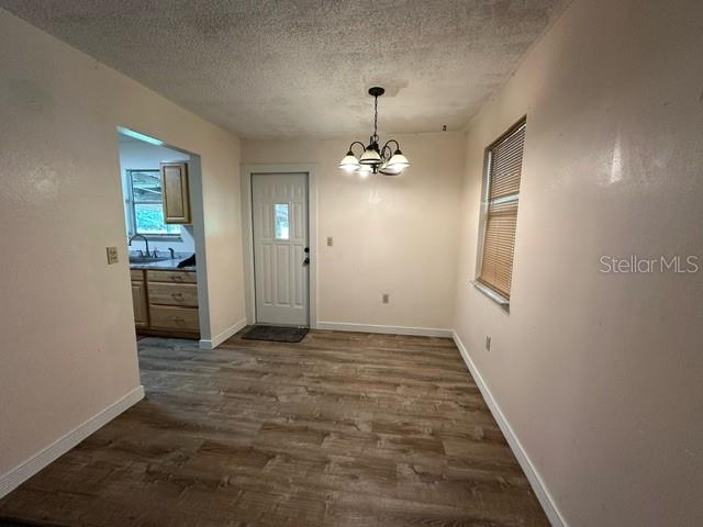 interior space featuring a notable chandelier, dark hardwood / wood-style flooring, and a textured ceiling