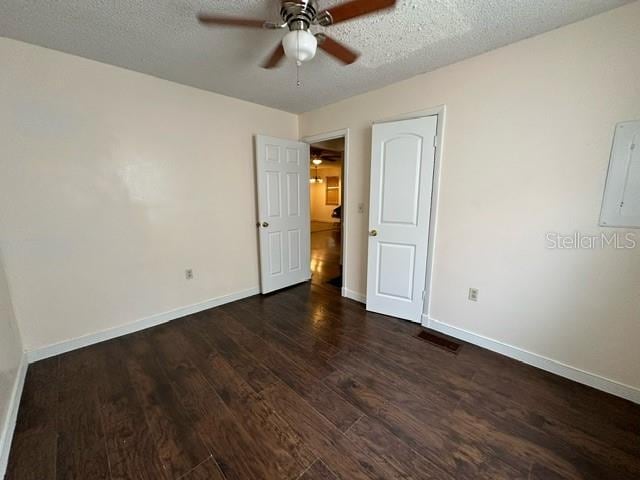 unfurnished bedroom featuring a textured ceiling, ceiling fan, and dark hardwood / wood-style flooring