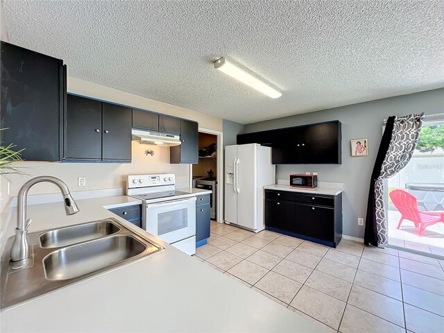 kitchen featuring white appliances, sink, a textured ceiling, and light tile patterned floors