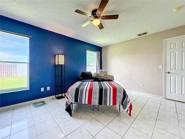 unfurnished bedroom with ceiling fan and a textured ceiling