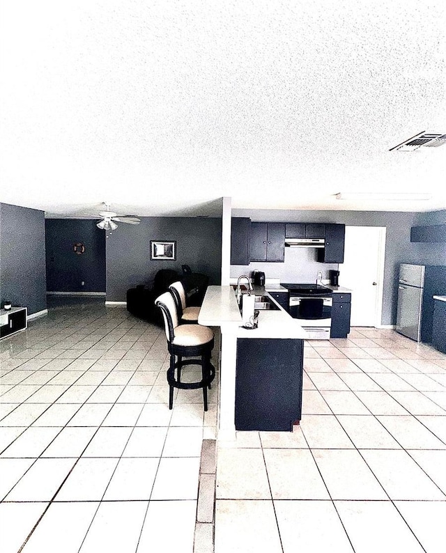 interior space featuring a breakfast bar, sink, kitchen peninsula, and light tile patterned floors