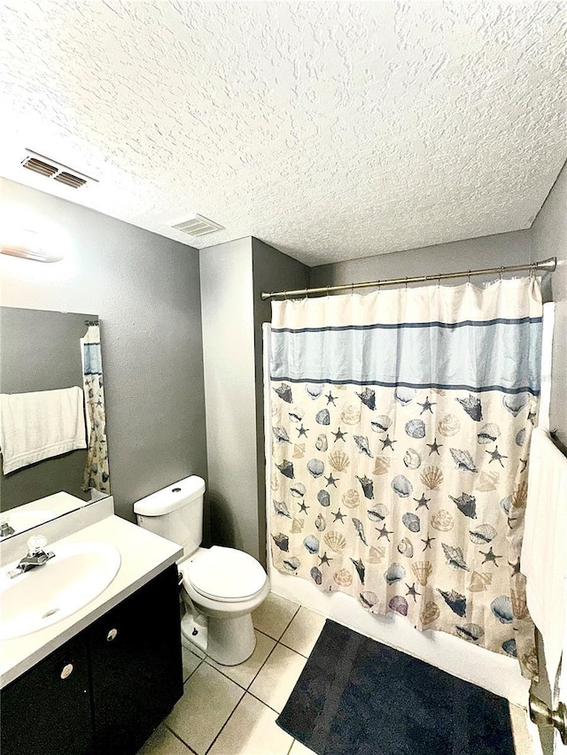 bathroom with tile patterned floors, toilet, vanity, and a textured ceiling