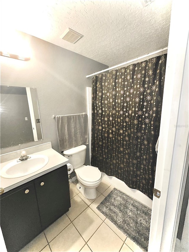 bathroom with vanity, a textured ceiling, curtained shower, tile patterned floors, and toilet