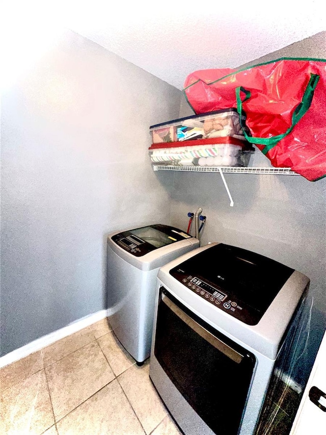 clothes washing area with tile patterned flooring and washer and dryer