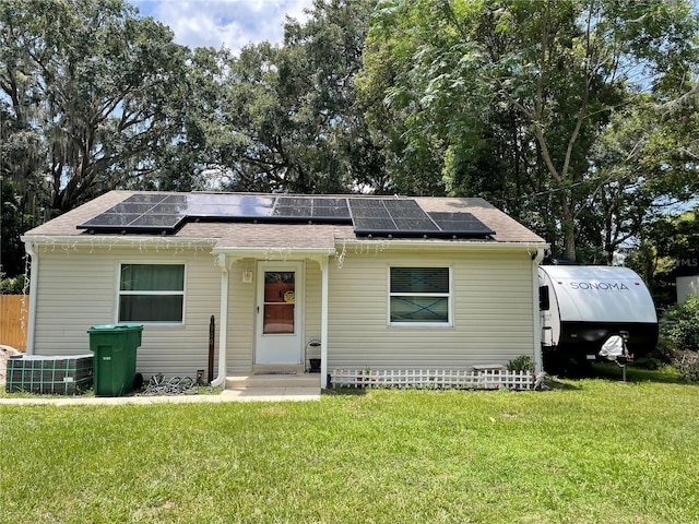 view of front facade with solar panels and a front lawn