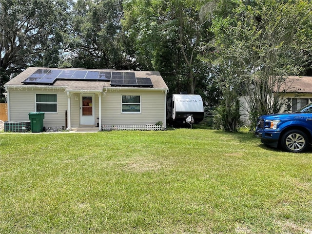 view of front of house featuring a front yard and solar panels