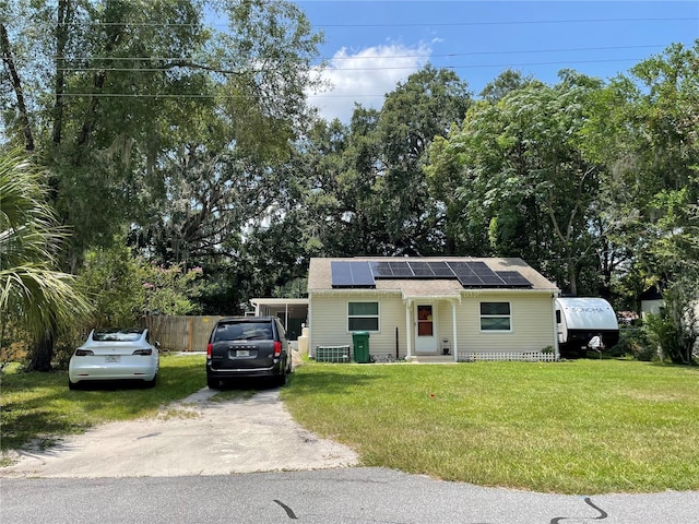 view of front of house featuring a front yard and solar panels