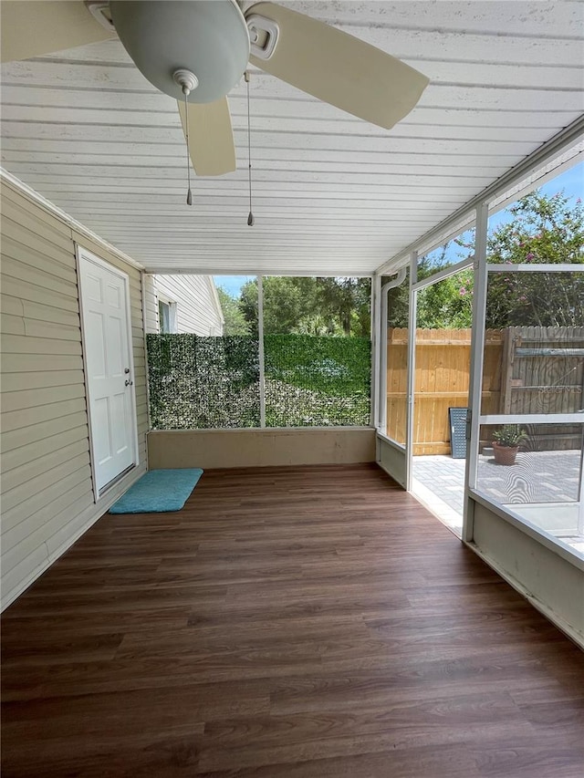 unfurnished sunroom with ceiling fan