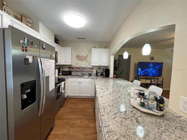 kitchen featuring appliances with stainless steel finishes, white cabinetry, sink, and hardwood / wood-style floors