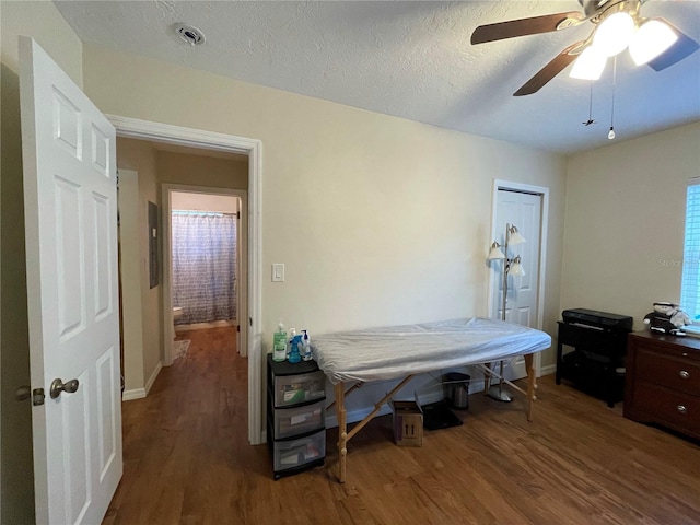 bedroom featuring wood-type flooring, ceiling fan, and a textured ceiling