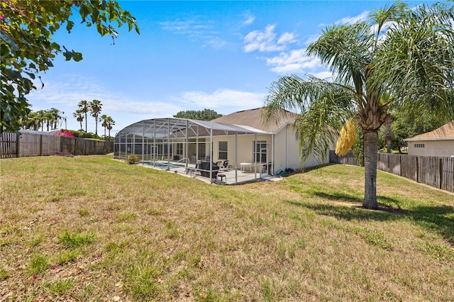 view of yard with glass enclosure, a fenced in pool, and a patio