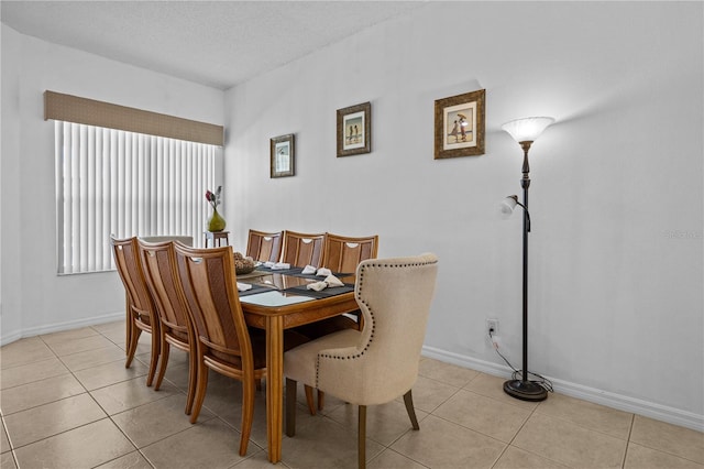 tiled dining space featuring a textured ceiling