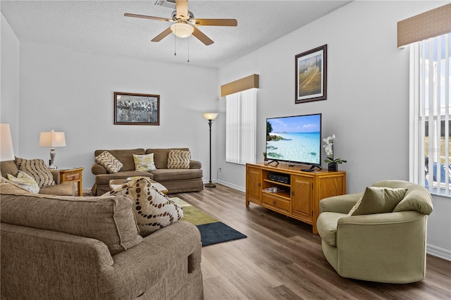 living room featuring a wealth of natural light, dark hardwood / wood-style flooring, and ceiling fan