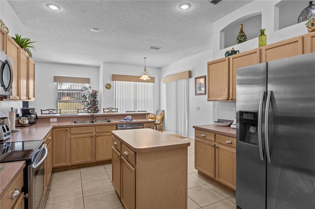 kitchen featuring light tile flooring, stainless steel appliances, a center island, sink, and a textured ceiling