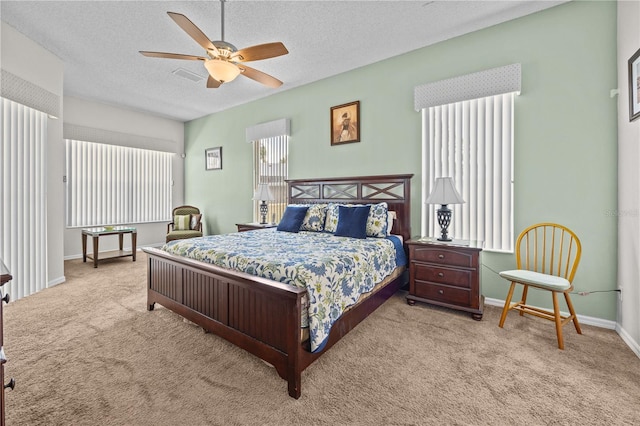 carpeted bedroom with ceiling fan and a textured ceiling