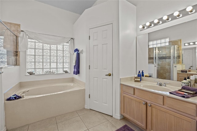 bathroom with a healthy amount of sunlight, tile flooring, plus walk in shower, and vanity