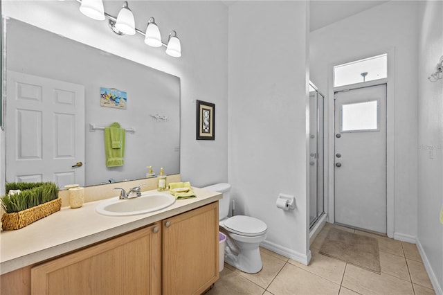 bathroom with tile flooring, vanity with extensive cabinet space, an enclosed shower, and toilet