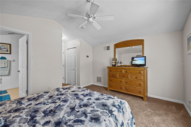 carpeted bedroom featuring a closet, ensuite bathroom, ceiling fan, a textured ceiling, and lofted ceiling